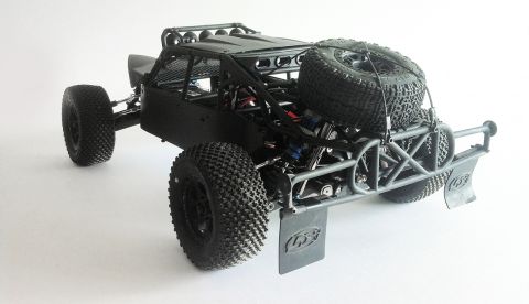 1986 Ford Bronco - This black off-road buggy features a prominent spare tire secured to its rear roll cage, suggesting it is built for terrain.