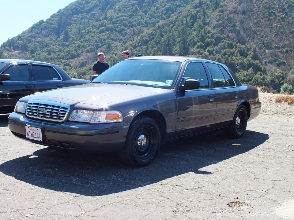 Gray Ford Crown Victoria sedan with steel wheels parked on mountain pullout