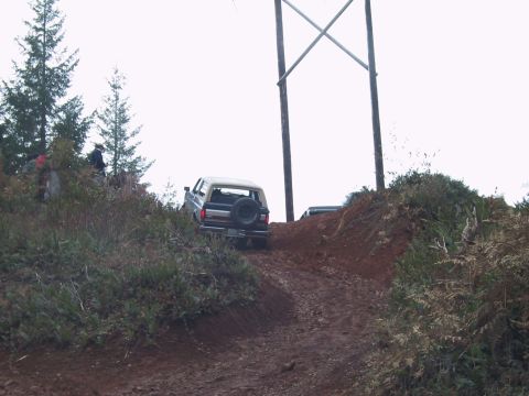 1991 Ford Bronco - Ford Bronco navigates a steep dirt incline, with another vehicle parked above.