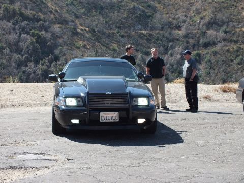 2003 Ford Crown Victoria - Blacked-out Crown Victoria with bull bar and EVIL VIC plate at a hilltop pullout.