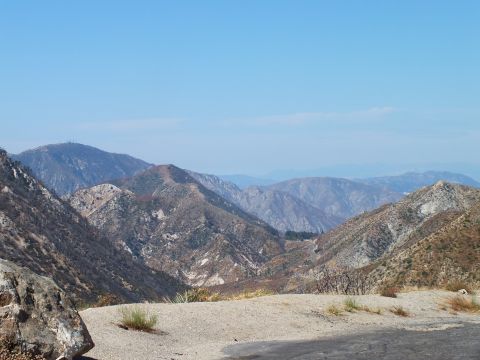 2003 Ford Crown Victoria - Distant brown and gray mountain ranges fading into haze beyond a gravel pullout