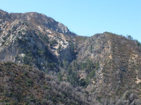 2003 Ford Crown Victoria - Rugged ridges of chaparral and exposed rock rise under a clear sky.