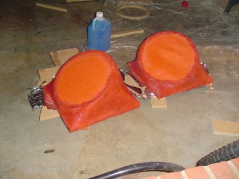 1999 Ford Taurus - Two custom-made speaker enclosures, covered in orange material, sit on a workshop floor.