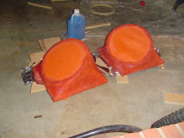 two orange custom speaker enclosures on a concrete floor