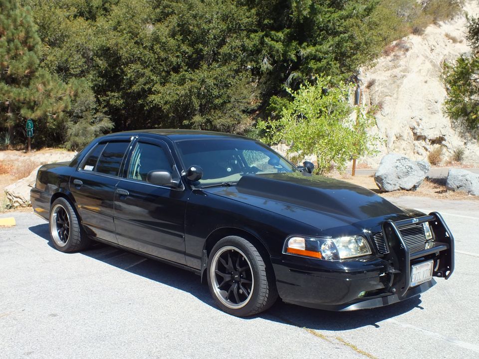 Black Ford Crown Victoria front three-quarter with billet grille and push bar by rocks