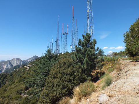 2003 Ford Crown Victoria - Tall radio and TV antenna masts rise from a pine-covered summit above hazy mountain ranges.
