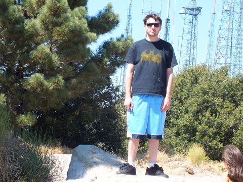2003 Ford Crown Victoria - Person in sunglasses poses on a peak with broadcast antenna masts rising behind