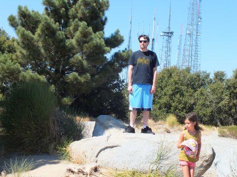 2003 Ford Crown Victoria - Adult and child stand near rocks on a summit fringed by radio transmission masts