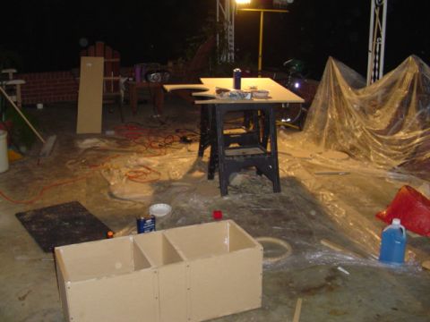 1999 Ford Taurus - A nighttime scene shows unfinished wooden boxes and various construction materials scattered across a concrete floor, suggesting an ongoing…