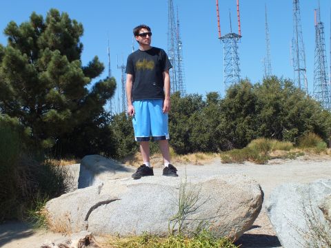 2003 Ford Crown Victoria - Person in dark tee stands atop a rock at a mast-covered mountain summit