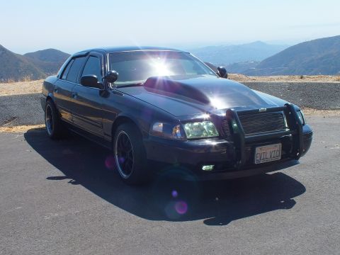 2003 Ford Crown Victoria - Blacked-out Crown Vic showing EVIL VIC plate and grille guard, sun flaring on hood