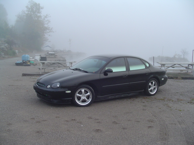 1999 Ford Taurus sedan parked on gravel with fog in background