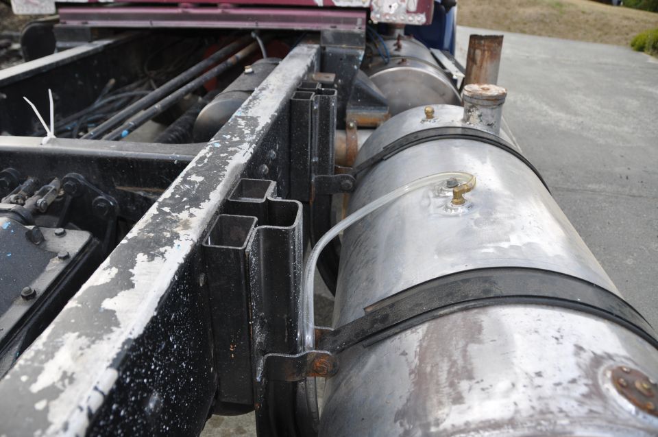 Close-up of a truck's frame rails and two large aluminum fuel tanks