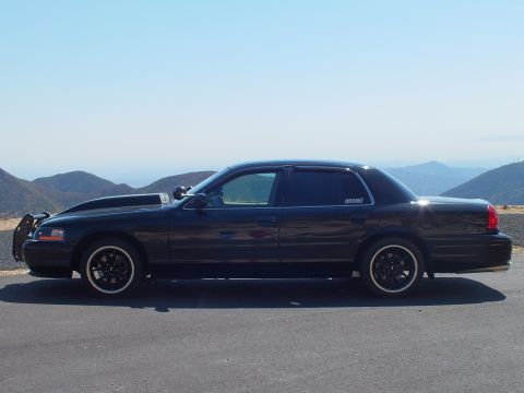 2003 Ford Crown Victoria - Profile shot of a blacked-out Mercury Grand Marquis at a scenic pullout in dry hills.