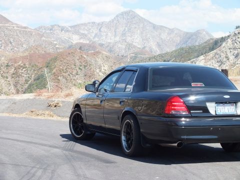 2003 Ford Crown Victoria - Rear three-quarter of a black Mercury Grand Marquis showing taillights and EVIL VIC plate.