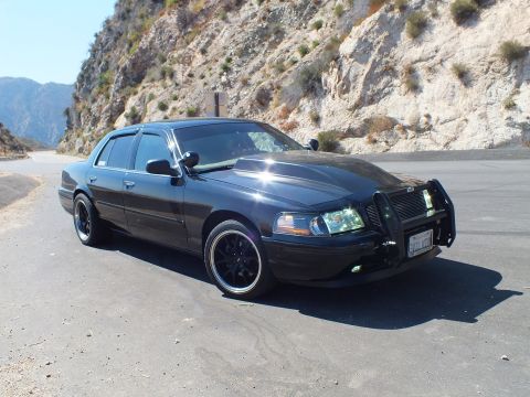 2003 Ford Crown Victoria - Front-quarter of a murdered-out Crown Vic, sun reflecting off the hood at a canyon turnout.
