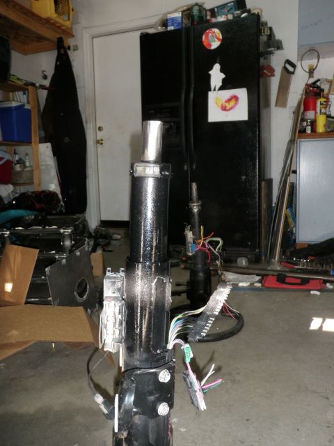 1961 International Scout 800 - A disassembled steering column with exposed wiring sits on a garage floor.
