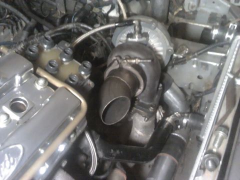 1995 Ford Probe - Close-up view of a turbocharger installed in an engine bay, with visible exhaust and intake piping.