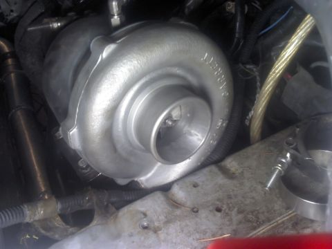 1995 Ford Probe - Close-up view of a Garrett turbocharger installed in an engine bay.