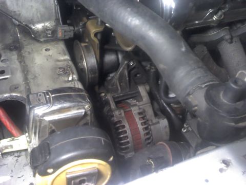 1995 Ford Probe - Close-up view of the alternator and associated engine components.