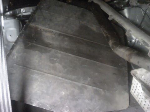1995 Ford Probe - A view of the underbody of a vehicle, showing a large panel and exhaust components.