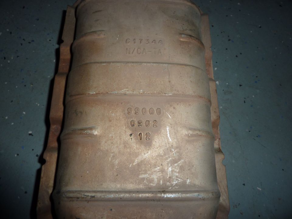 Catalytic converter with part numbers 617360 N/CA-1A and 99000 0902 12 stamped on it