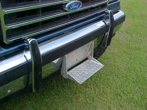 1992 Ford Bronco - Close-up of the front grille and bumper of a 1992 Ford Bronco, a fold-down step.