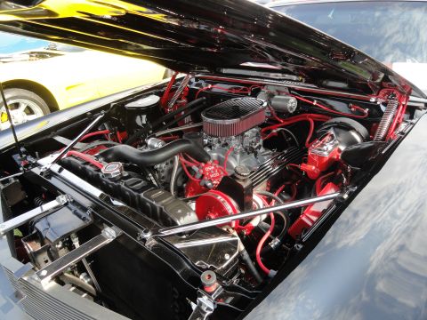 1964 Ford Fairlane - A detailed view of a custom engine bay, with a yellow car visible in the background.