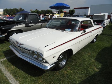 1964 Ford Fairlane - A white 1962 Chevrolet Impala coupe is displayed at an outdoor car show.