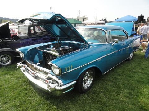 1964 Ford Fairlane - A classic blue Chevrolet is displayed with its hood open at an outdoor car show.