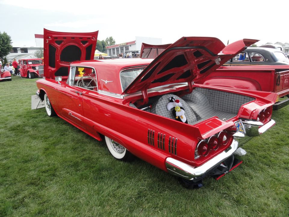 Red 1958 Ford Thunderbird with hood and trunk open, showing interior and spare tire with Sylvester the Cat plush toy