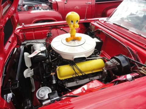 1964 Ford Fairlane - The engine bay of a red 1964 Ford Fairlane is visible, adorned with a Tweety Bird figurine.