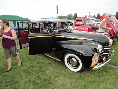 1964 Ford Fairlane - A black 1940 Ford Sedan is displayed at a car show with its doors open.