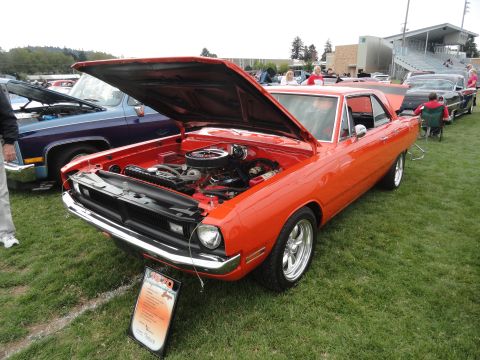 1964 Ford Fairlane - An orange 1968 Dodge Dart is displayed with its hood open at a car show, alongside other vehicles.