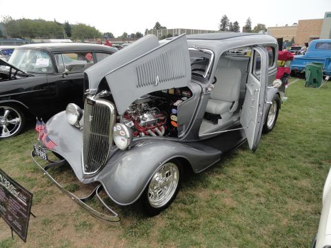 1964 Ford Fairlane - A classic 1933 Ford hot rod is displayed with its engine and interior visible at an outdoor car show.