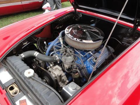 1964 Ford Fairlane - The engine bay of a red 1964 Ford Fairlane reveals a blue 351-4V V8 engine with a chrome air cleaner and a visible radiator.
