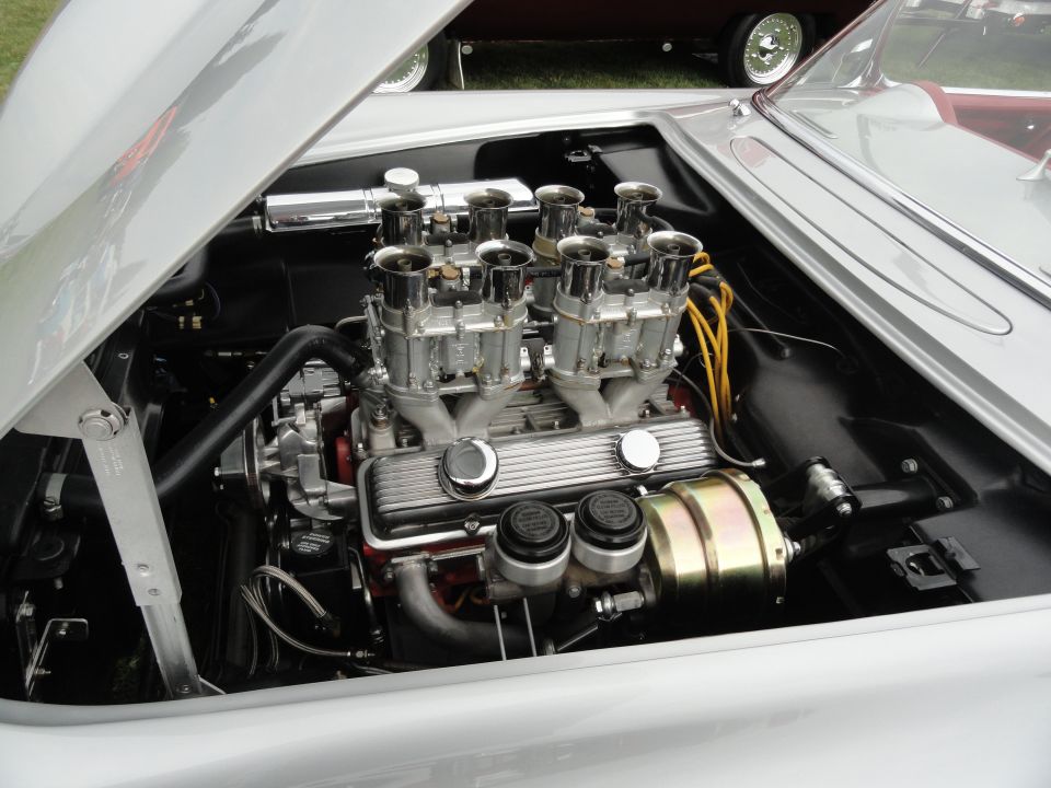 Close-up of a V8 engine with six carburetors and yellow spark plug wires