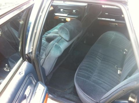 1991 Ford LTD Crown Victoria - Interior of a dark blue sedan, showing velour seats and wood trim details.