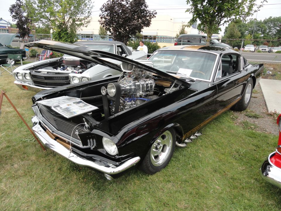 Black 1965 custom coupe with supercharger and side pipes