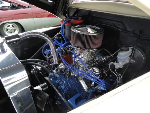 1964 Ford Fairlane - A detailed view of a car's engine bay, its components and wiring, with another vehicle partially visible.