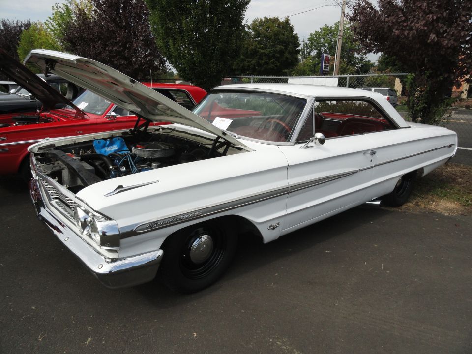 1964 Ford Fairlane with hood open, red interior, parked next to a red car
