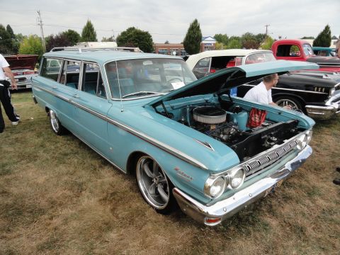 1964 Ford Fairlane - A light blue 1962 Mercury Comet station wagon is displayed with its hood open at an outdoor car show.