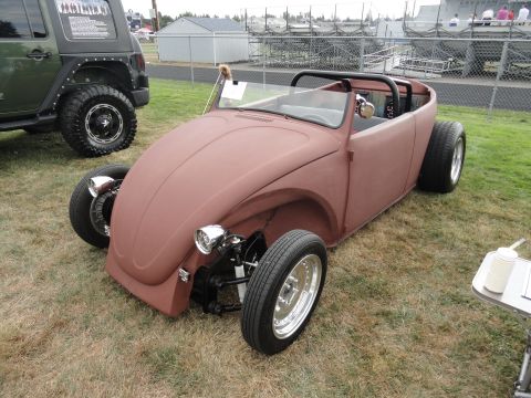 1964 Ford Fairlane - A custom Volkswagen Beetle convertible is displayed at a car show, with a Jeep visible in the background.