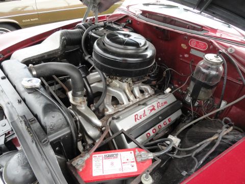 1964 Ford Fairlane - The engine compartment of a red car shows a Dodge Red Ram V8 engine, with a second vehicle visible in the background.