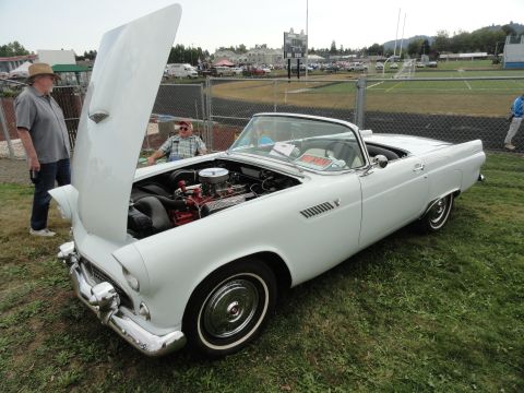 1964 Ford Fairlane - A white 1955 Ford Thunderbird convertible is displayed with its hood open at a car show.