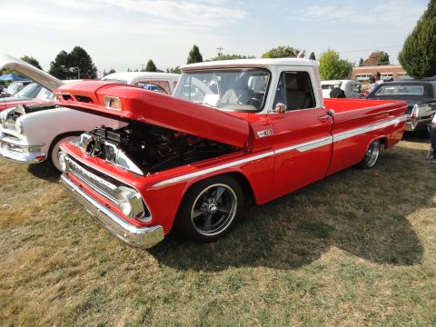 1964 Ford Fairlane - A red and white 1964 Chevrolet C10 pickup truck is displayed with its hood open at a car show.