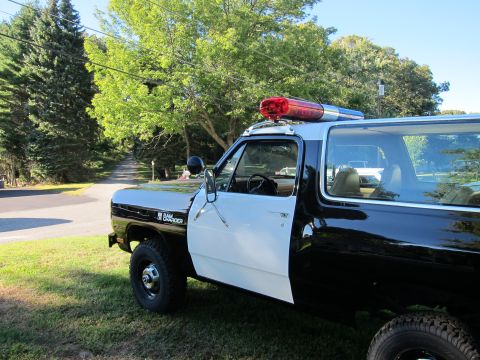 1987 Dodge 1500 - This black and white SUV is equipped with a light bar, suggesting it was once used as a police vehicle.