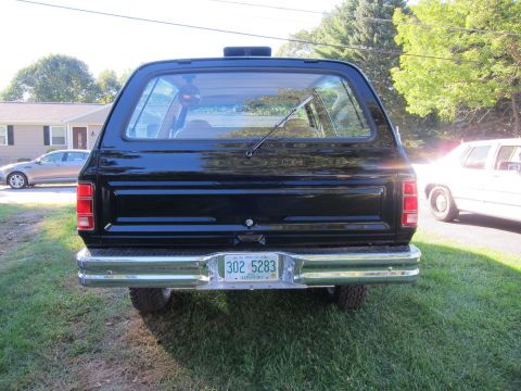 1987 Dodge 1500 - Rear view of a black SUV with a chrome bumper and a license plate.