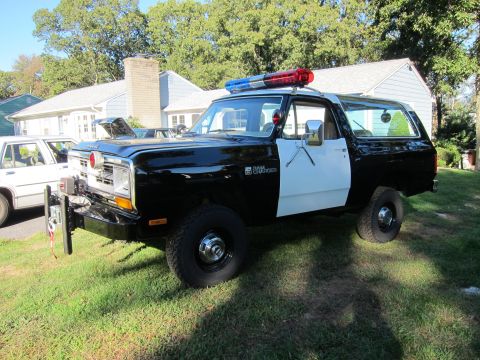 1987 Dodge 1500 - This 1987 Dodge 1500 police SUV is parked on a grassy lawn in front of a house.