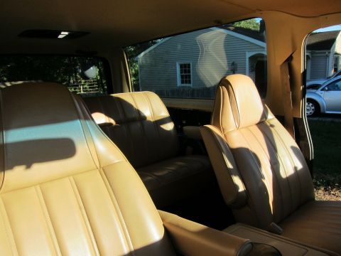 1987 Dodge 1500 - Interior view of a truck, showing tan seats and the exterior through the windows.